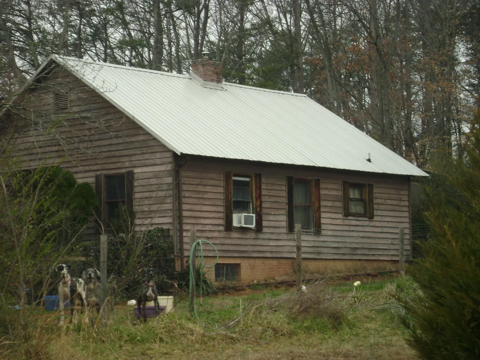 White metal roof on an old wood sided farmhouse, from a Metal Roof Installation job in Carrollton